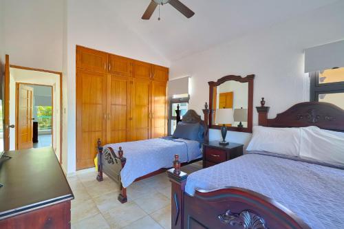 a bedroom with two beds and a mirror at Comfy Spacious Villa W- Pool, Jacuzzi, Bbq in Juan Dolio