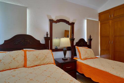 a bedroom with two beds and a mirror at Comfy Spacious Villa W- Pool, Jacuzzi, Bbq in Juan Dolio