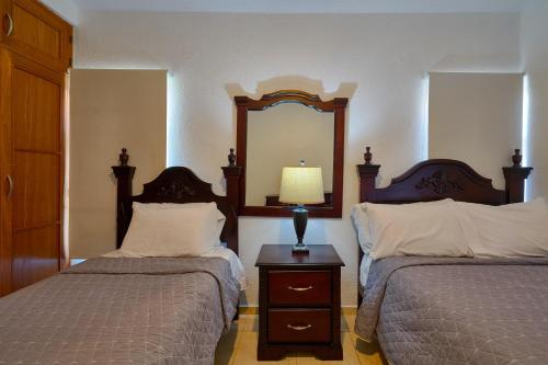 a bedroom with two beds and a mirror on the wall at Comfy Spacious Villa W- Pool, Jacuzzi, Bbq in Juan Dolio