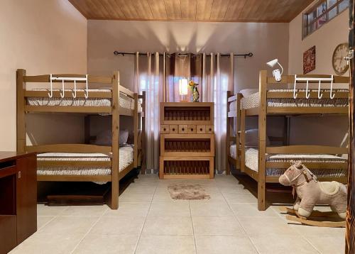 Zimmer mit 3 Etagenbetten und einem Spielzeugpferd in der Unterkunft Mia Volcan in Volcán