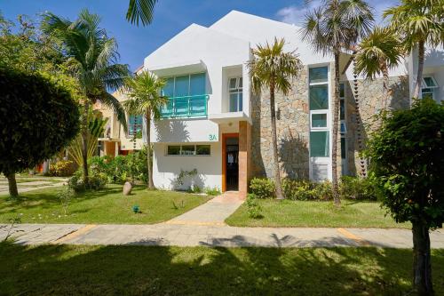 a house with palm trees in front of it at Comfy Spacious Villa W- Pool, Jacuzzi, Bbq in Juan Dolio