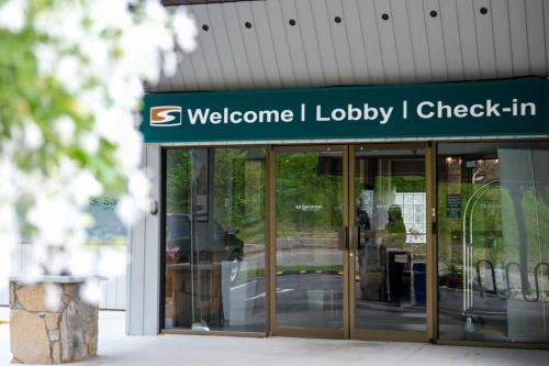 a building with a sign that reads welcome to lobby check in at Sandman Hotel Revelstoke in Revelstoke