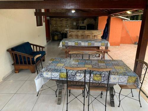 a patio with tables and chairs in a room at Sana - Chácara Canto do Tiê - 15 hospedes in Casimiro de Abreu