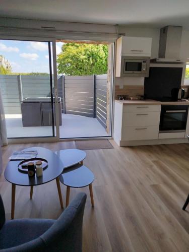 un salon avec une table et une cuisine dans l'établissement Petite maison, à Plouguerneau