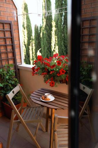 a table and chairs on a balcony with flowers at Il Giardino di Cristina - A literary B&B in Chianti in Vagliagli