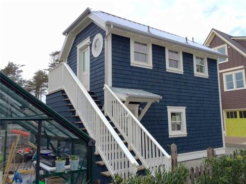 una casa azul con una escalera blanca y un reloj en The Ladybug by Seabrook Hospitality, en Pacific Beach