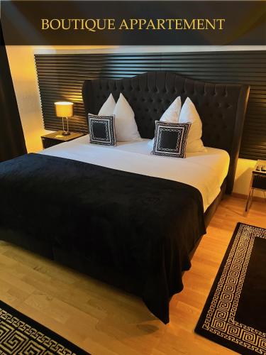Schlafzimmer mit einem großen Bett mit einem schwarzen Kopfteil in der Unterkunft Boutique Appartement in Torgau