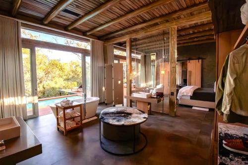 a room with a bedroom with a bed and a large window at Kapama Karula in Kapama Private Game Reserve