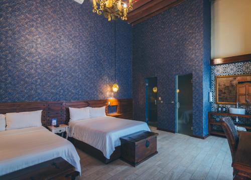 a hotel room with two beds and a chandelier at Hotel Boutique Casa Altamira in Querétaro