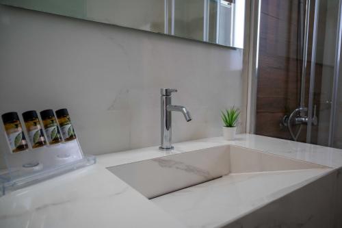 a sink in a bathroom with a faucet at Finikas Suites & Apartments Airport By Airstay in Artemida
