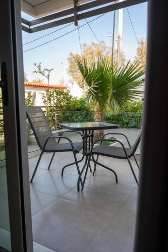 a patio with a table and chairs on a balcony at Finikas Suites & Apartments Airport By Airstay in Artemida