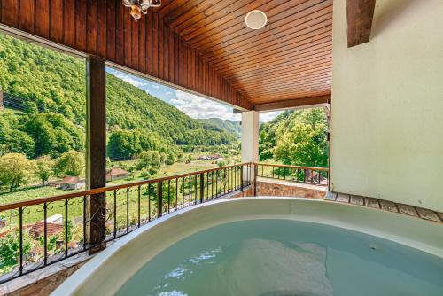an indoor hot tub in a house with a balcony at Pensiunea Apuseni Wild in Remeţi