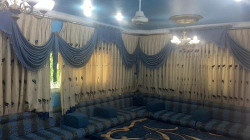 a room with couches and curtains and a chandelier at الاردن اربد الرمثا in Ar Ramthā