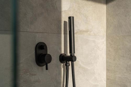 a shower with a phone attached to a wall at Philosophy of Mykonos Boutique Hotel in Mýkonos City