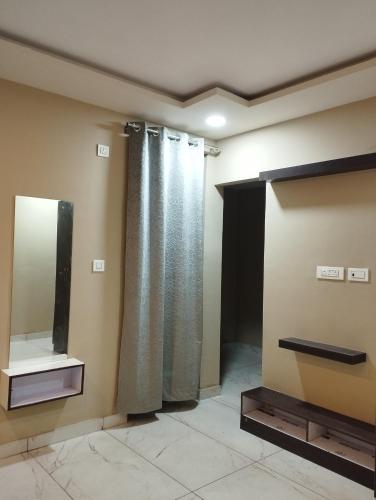 a bathroom with a shower curtain and a mirror at Lotus Inn River View in Shamshi