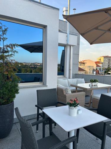 a patio with tables and chairs and a window at Hotel Conde de Agueda in Águeda