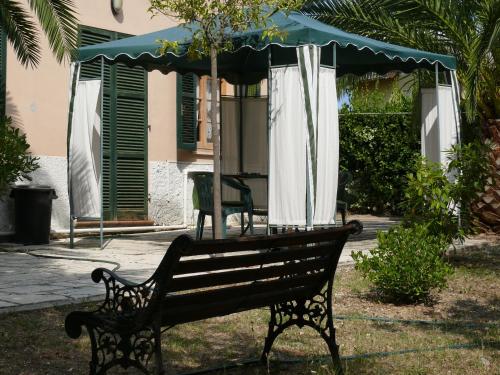 a park bench with an umbrella on top of it at Bed&Breakfast Giardino Agritourist in Controguerra