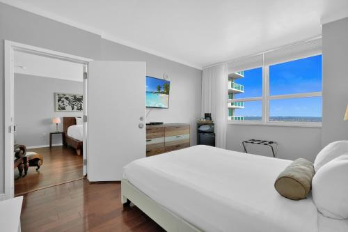 Un dormitorio blanco con una cama blanca y una ventana. en Fabulous 2 bedroom in Heart of Grove, en Miami