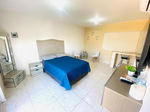 a bedroom with a blue bed and a desk at Departamento Piso 3 in Mazatlán