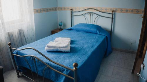 a blue bedroom with a bed with towels on it at La dimora di Annarè in SantʼEufemia Lamezia