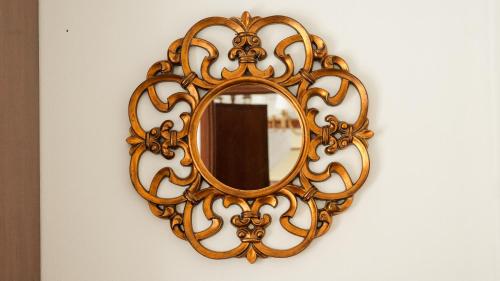 a gold mirror hanging on a wall at La dimora di Annarè in SantʼEufemia Lamezia