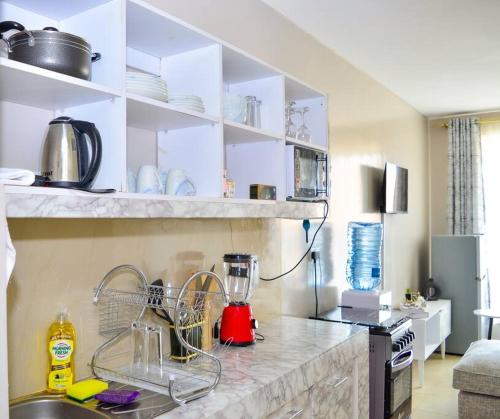 Una cocina con gabinetes blancos y encimera. en Mels Cosy Homes, en Nairobi