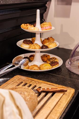 three tiered plates of pastries and pies on a counter at Grand Hotel Alkmaar in Alkmaar