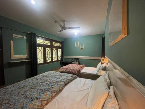 a bedroom with two beds and a window at Skardu Lodge in Skardu