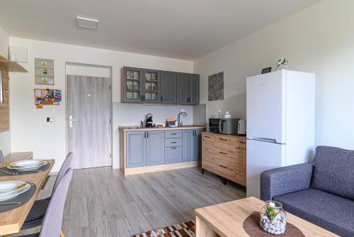 a kitchen and living room with a refrigerator and a table at Apartmán Family in Liptovský Mikuláš