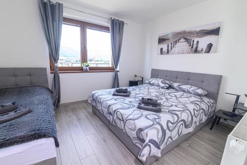 a bedroom with a bed and a window at Apartmán Family in Liptovský Mikuláš