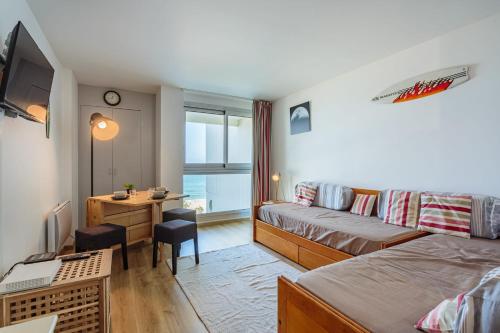 Cette petite chambre comprend un lit, un bureau et un canapé. dans l'établissement Studio Océan vue mer - Welkeys, à Biarritz