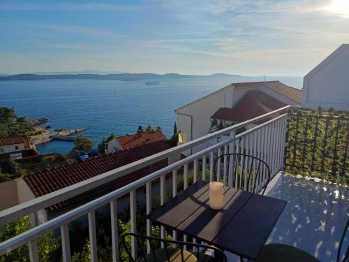 Un balcón con una mesa y vista al agua. en NatasaHvar, en Hvar