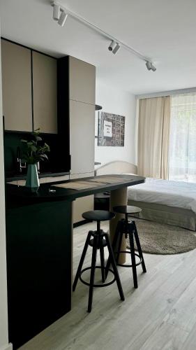 a room with a desk with two stools and a bed at Platon Residence Apartments in Łódź