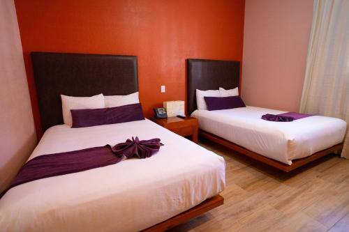 Hotel Suites Corazón Mexicano tesisinde bir odada yatak veya yataklar