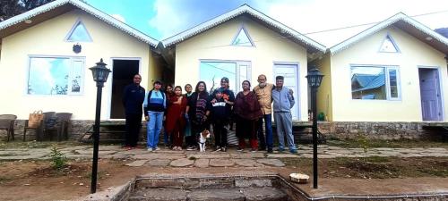a group of people standing in front of a house at THE HIDEAWAY Homestay Chail in Chail