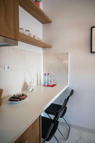 a kitchen with a white counter and a black chair at Finikas Suites & Apartments Airport By Airstay in Artemida