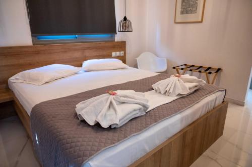 a bedroom with two beds with towels on them at Finikas Suites & Apartments Airport By Airstay in Artemida