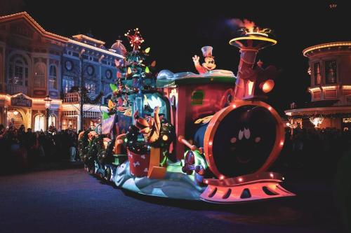 a train parade in front of a christmas tree at Cosy Apartment - Parking, Garden,10mn from Disneyland! in Montévrain