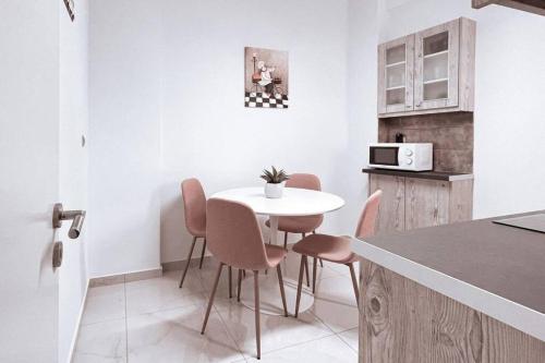 una piccola cucina con tavolo e sedie bianchi di Penthouse - Amazing View in the Center of Athens ad Atene