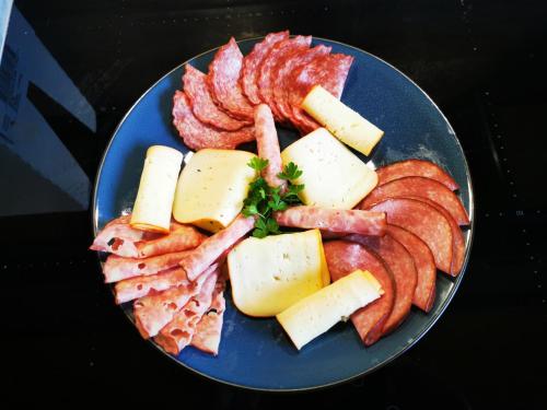 a blue plate of food with bacon and cheese at Haus Sonnblick in Pusterwald