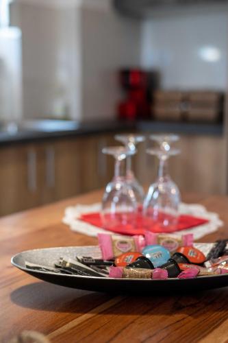 a plate with two wine glasses on a table at Finikas Suites & Apartments Airport By Airstay in Artemida