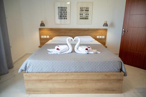 two white swans sitting on top of a bed at Finikas Suites & Apartments Airport By Airstay in Artemida