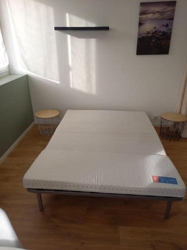 un lit assis dans une pièce à côté d'une fenêtre dans l'établissement Joli studio à 5mn du centre-ville avec parking privé, à Castres