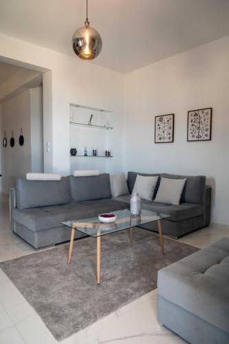 a living room with a couch and a coffee table at Finikas Suites & Apartments Airport By Airstay in Artemida