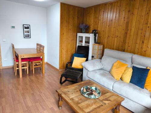 una sala de estar con un sofá y una mesa en Apartamento Diezcapanas, en Villanúa