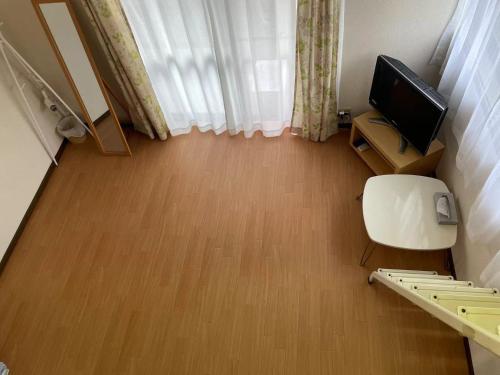a small room with a television and a wooden floor at Real Corp 101 - Vacation STAY 06884v in Chiba