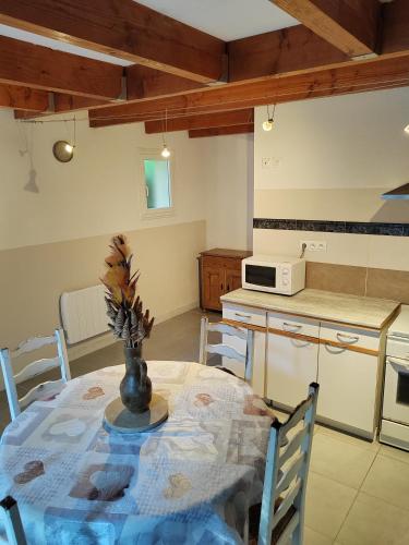 une cuisine avec une table avec un vase dessus dans l'établissement Le frais ruisseau, à Nant