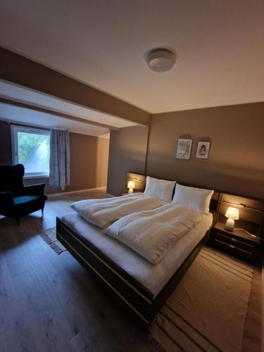 a bedroom with a large bed and a chair at Eidsvåg in Bergen