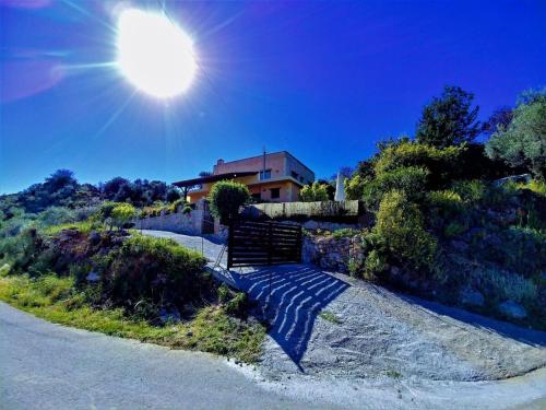 a house on the side of a road with the sun at Thymes traditional house in Loúlos
