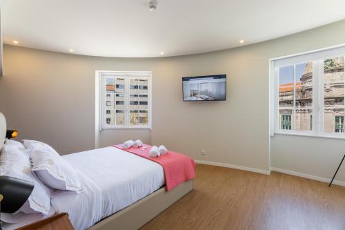 a bedroom with a bed and a tv on the wall at BESTVILLAS Plaza in Braga
